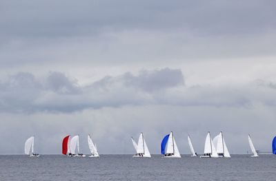 Sailboats sailing in sea against sky