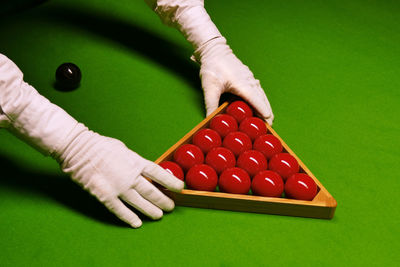 Cropped image of hands arranging snooker balls on table