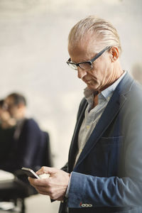 Senior businessman using mobile phone in office