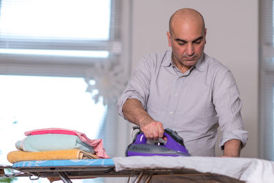 Man ironing clothes at home