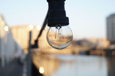 Close-up of illuminated lamp against sky