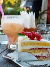 Close-up of cake slice and cocktail on table