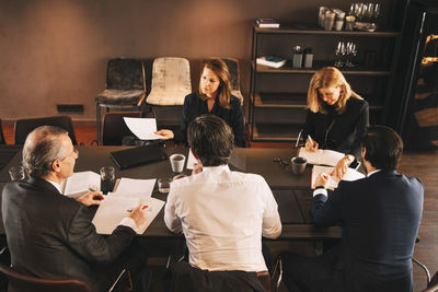 High angle view of financial advisors brainstorming in board room at office