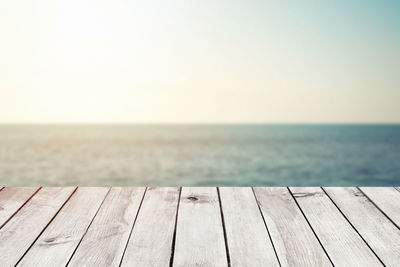 Close-up of pier over sea against clear sky