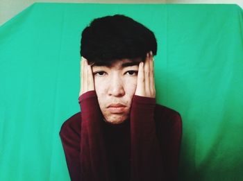 Portrait of young man against blue wall