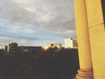 Buildings against cloudy sky at sunset