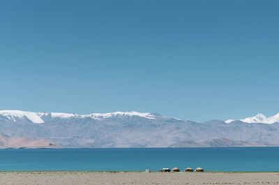 Scenic view of snowcapped mountains against clear blue sky