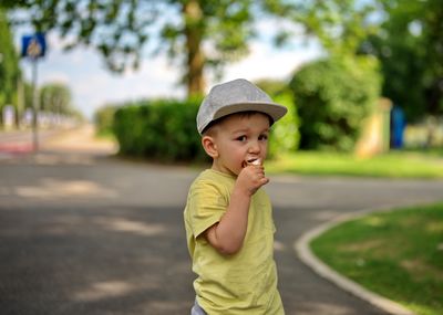 Portrait of little toddler in a park eating ice cream