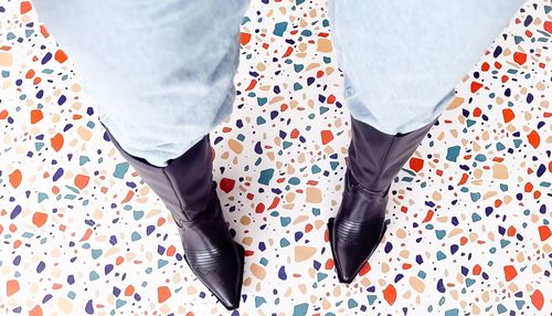 Low section of woman standing on bed