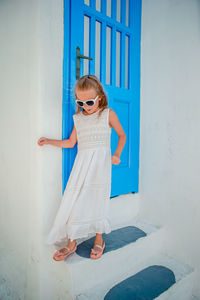 Young woman standing against wall