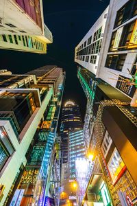 Low angle view of illuminated buildings in city at night