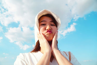 Low angle portrait of child against sky