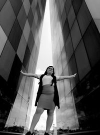 Low angle view of woman standing against modern building