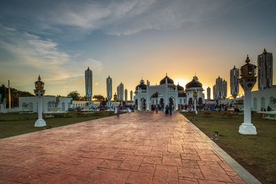 Panoramic view of city street and buildings against sky during sunset