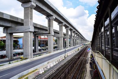 Railroad tracks by bridge against sky