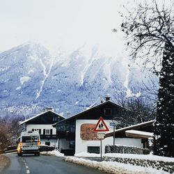 Snow covered houses and trees against sky