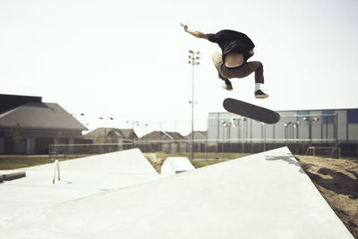 Young man performing stunts on skateboard