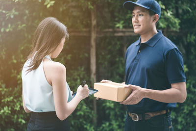 Young man holding woman standing outdoors