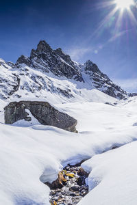 Low angle view of stream on snowcapped mountain against sky