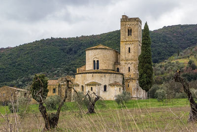 Old building by mountain against sky