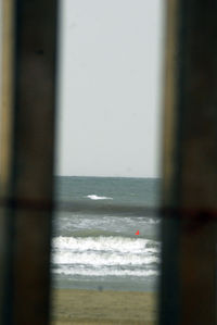 Scenic view of sea against sky seen through window