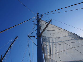 Low angle view of sailboat against clear blue sky