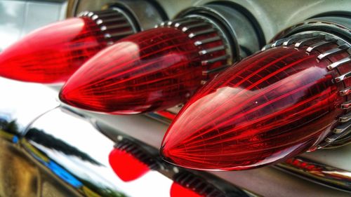 Close-up of red lighting equipment hanging on metal