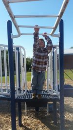 Boy playing on monkey bars at playground