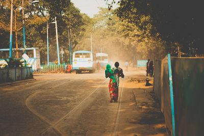 Rear view of man walking on street in city