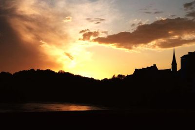 Silhouette buildings against sky during sunset