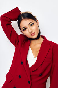 Portrait of young woman standing against white background