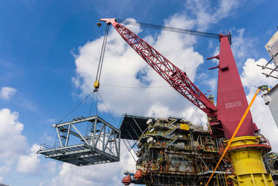 Low angle view of crane against sky