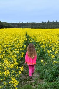 Rear view of girl standing on field