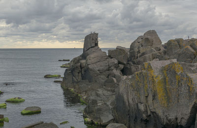 Rock formations on sea shore against sky