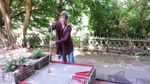 Side view of woman standing against trees