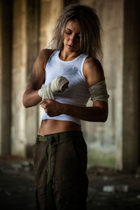 Female fighter wrapping bandage on hand