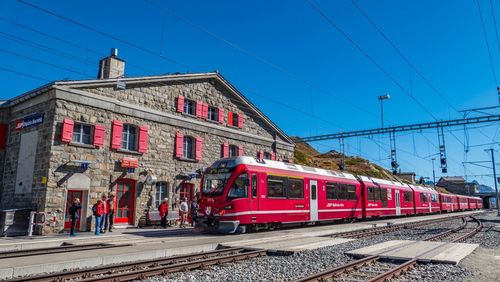 Train on railroad station platform against clear blue sky