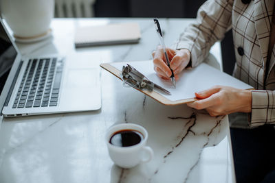 Midsection of doctor using laptop on table