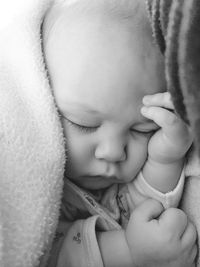 Close-up of baby sleeping on bed at home