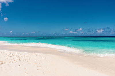 Scenic view of beach against blue sky