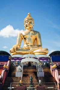 Low angle view of statue against temple against sky