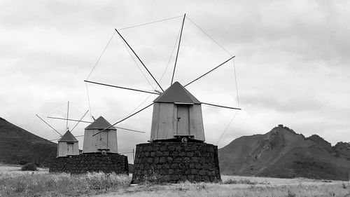 Traditional windmill on field against sky