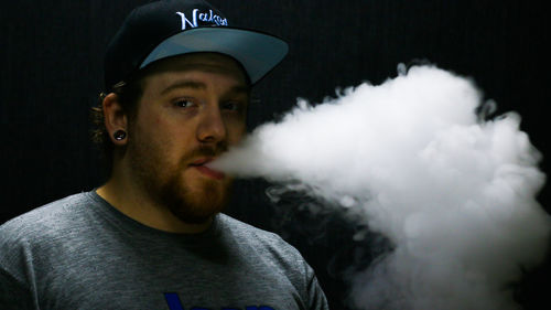 Portrait of young man smoking outdoors