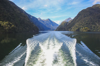 Scenic view of lake by mountains against sky