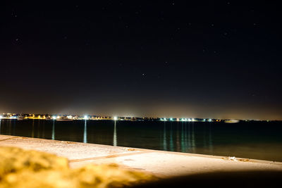 Scenic view of lake against clear sky at night