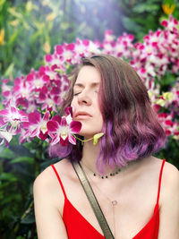 Portrait of beautiful woman with pink flower