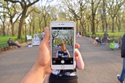 Digital composite image of woman photographing through smart phone