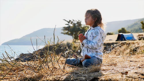 Full length of girl sitting on land