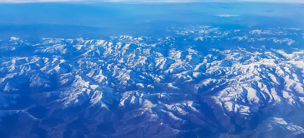 Aerial view of snowcapped mountains against sky