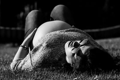 Pregnant woman lying on grassy field